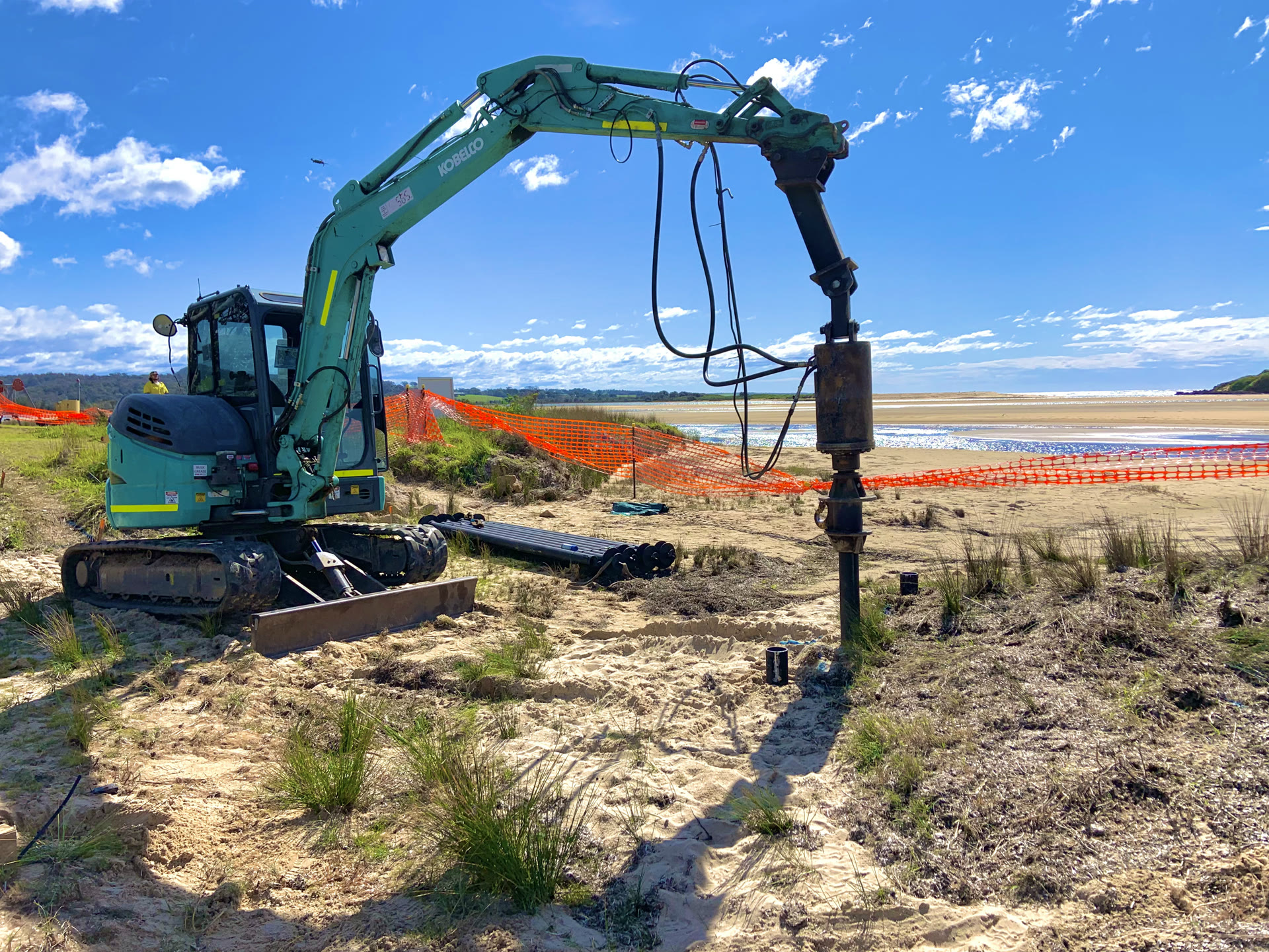 Screw pile installation beside water and established vegetation
