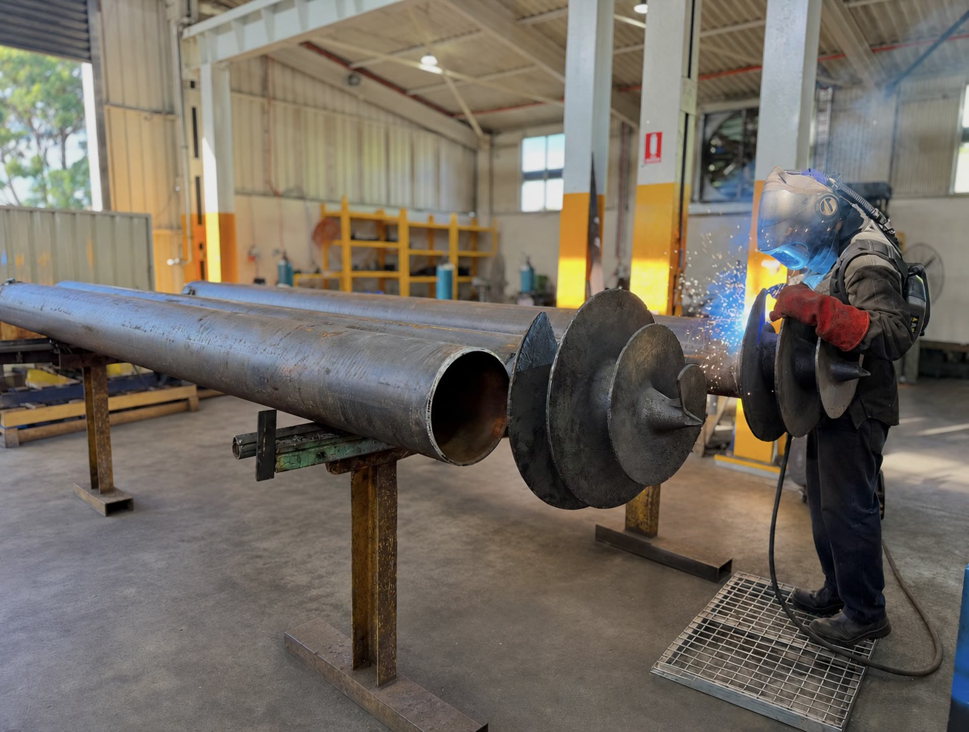Steel screw pile leg components prepared for installation